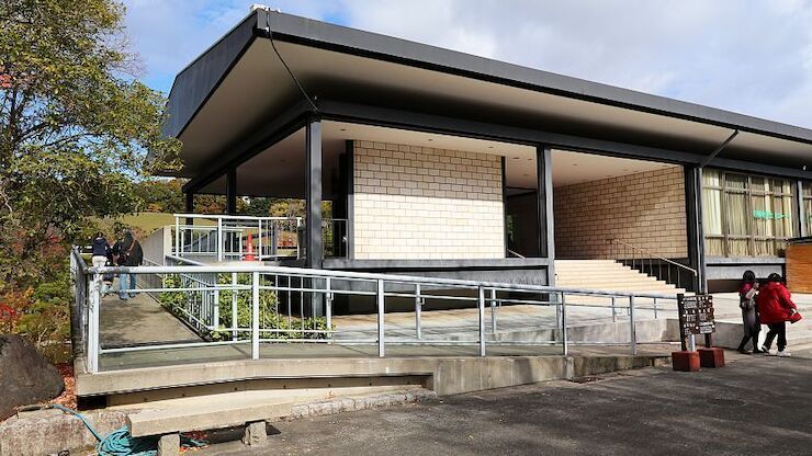 Access ramp with metal handrails beside steps leading to a building entrance in Japan