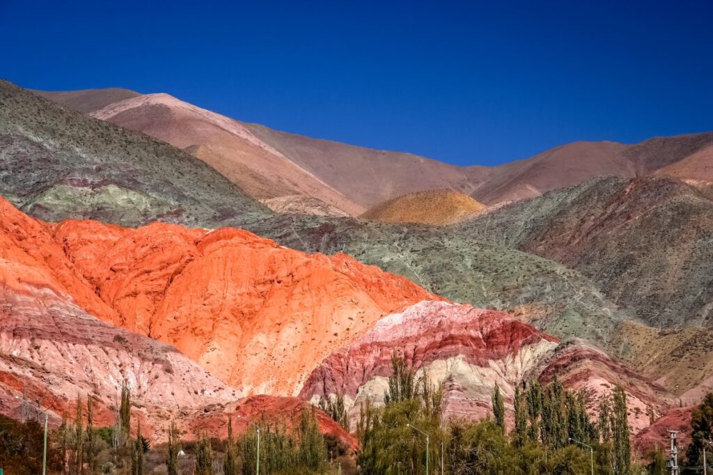 Colourful layered mountains in northern Argentina, with red, pink and green rock formations beneath a clear blue sky