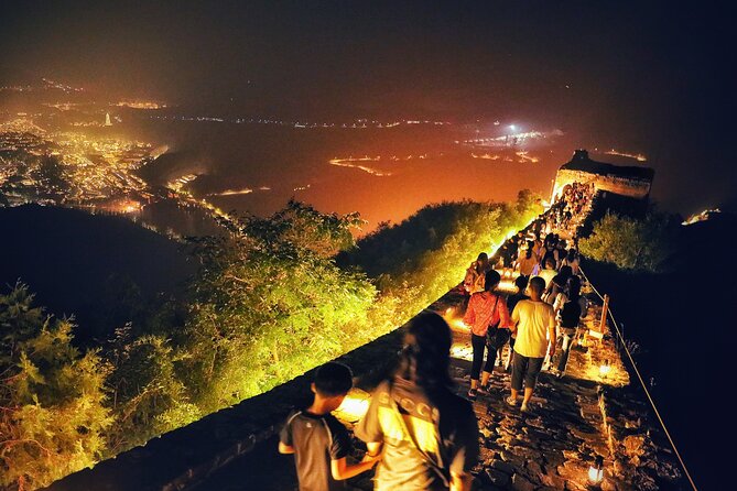 Visitors walking along an illuminated section of the Great Wall at night