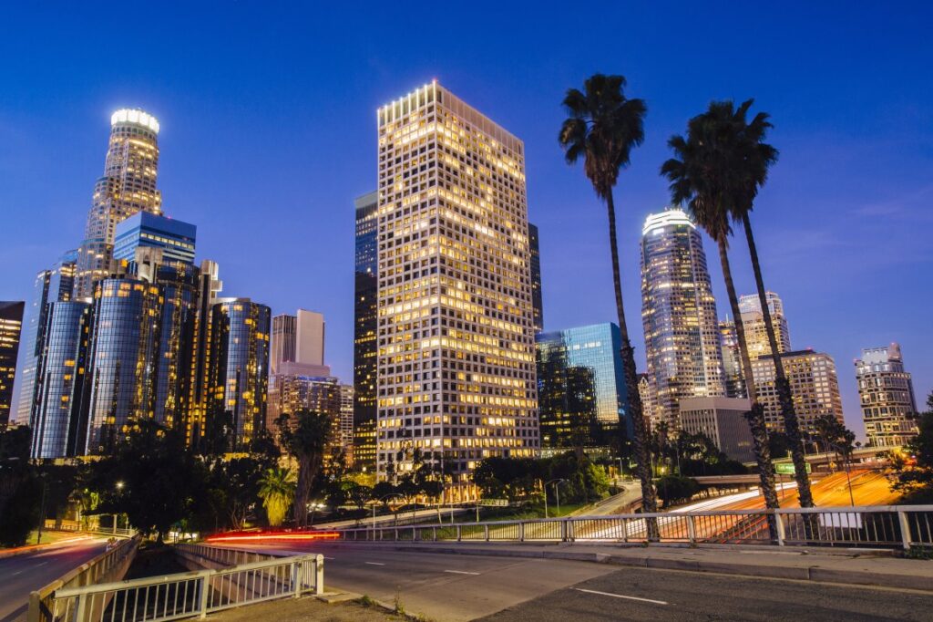 Downtown Los Angeles skyline with palm trees at dusk