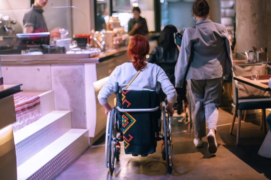 Wheelchair user moving through an accessible hotel interior