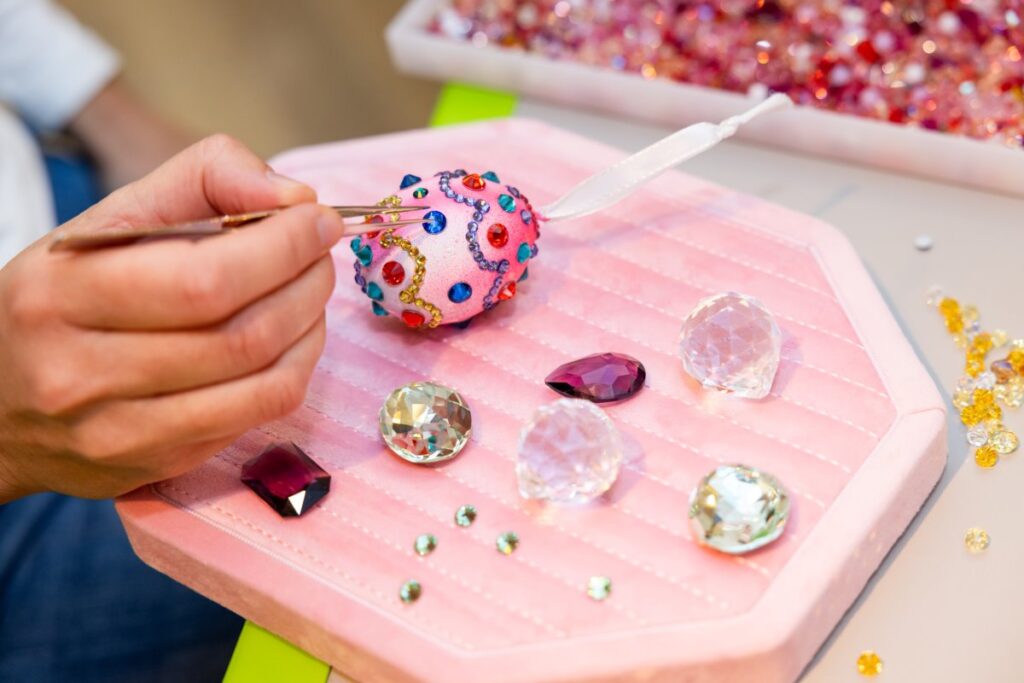 Swarovski crystals being applied by hand during a decorative design process