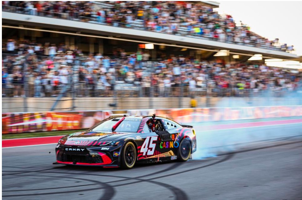 Race car in front of crowded grandstands at Circuit of the Americas