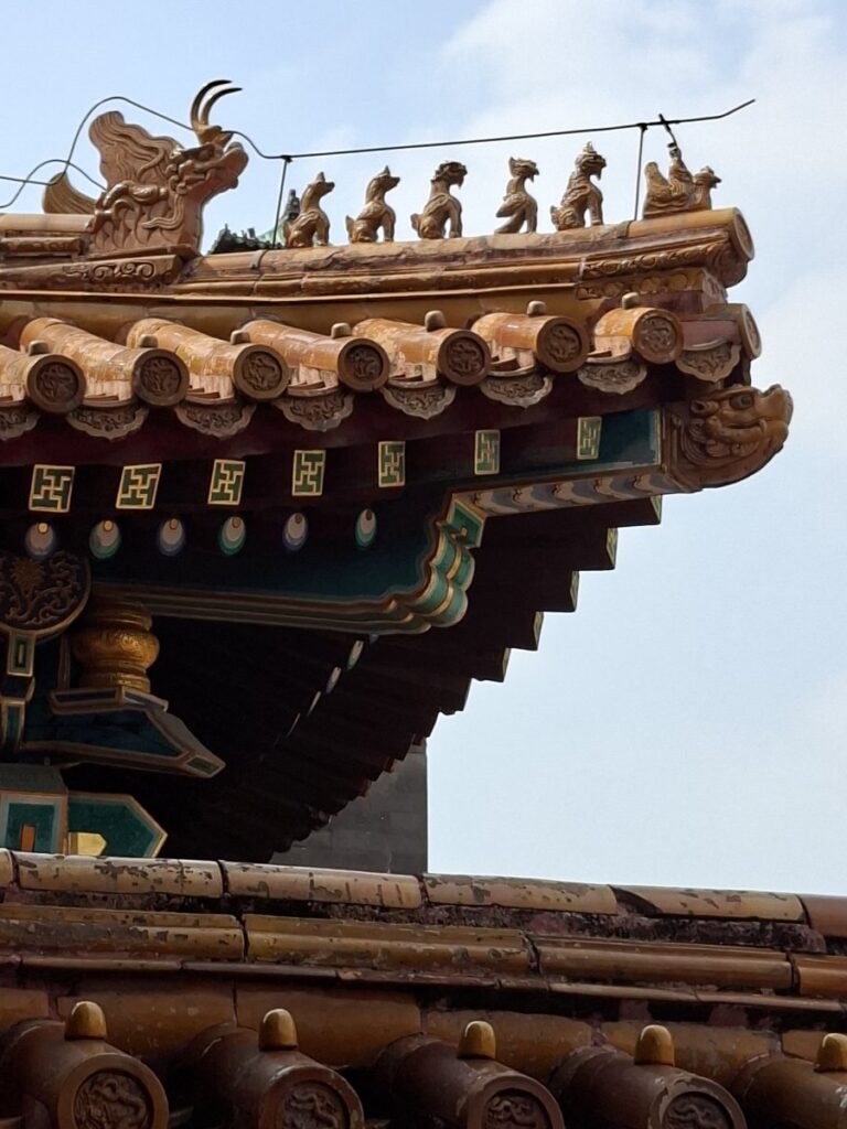 Decorative animal figures line the corner of a tiled roof at the Forbidden City in Beijing