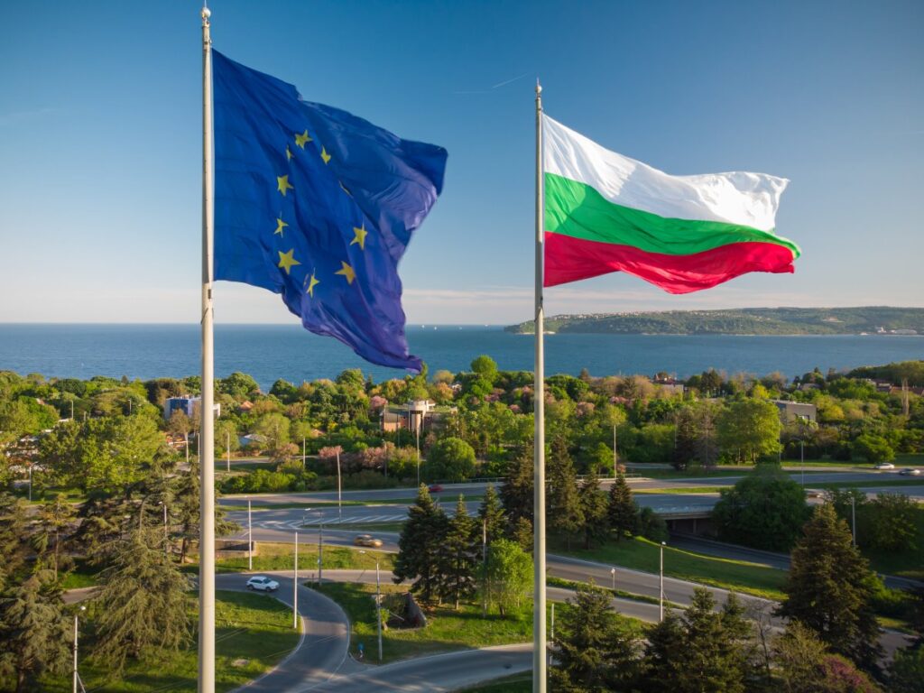 European Union and Bulgarian flags flying above a coastal landscape in Bulgaria