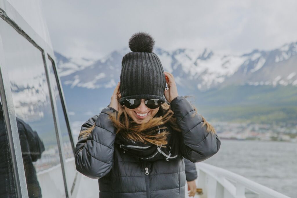 Traveller wearing warm layers on the deck of a Norwegian fjords cruise