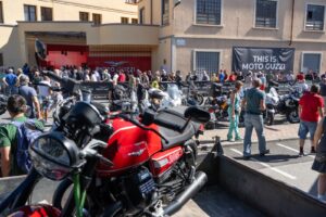Moto Guzzi motorcycles and visitors outside the factory in Mandello del Lario