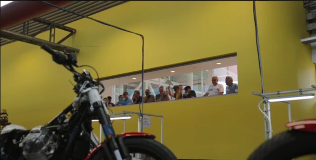 Visitors looking into the Moto Guzzi production area at the Mandello del Lario factory