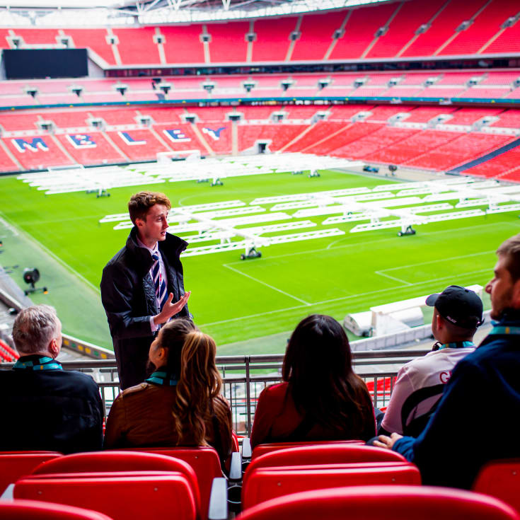 Wembley Stadium tours – guide speaking to visitors inside the stadium