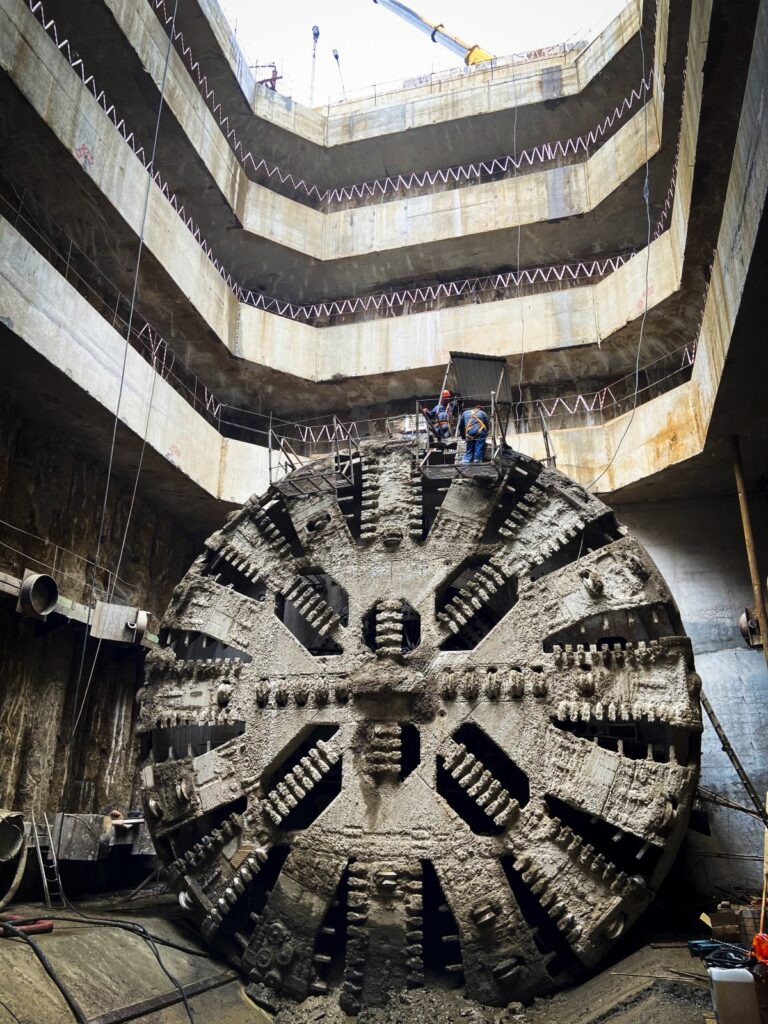 Large tunnel boring machine cutter head inside an underground construction shaft.