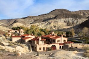 Scotty’s Castle in Death Valley, California, with red-tiled roofs and a tower surrounded by desert hills.